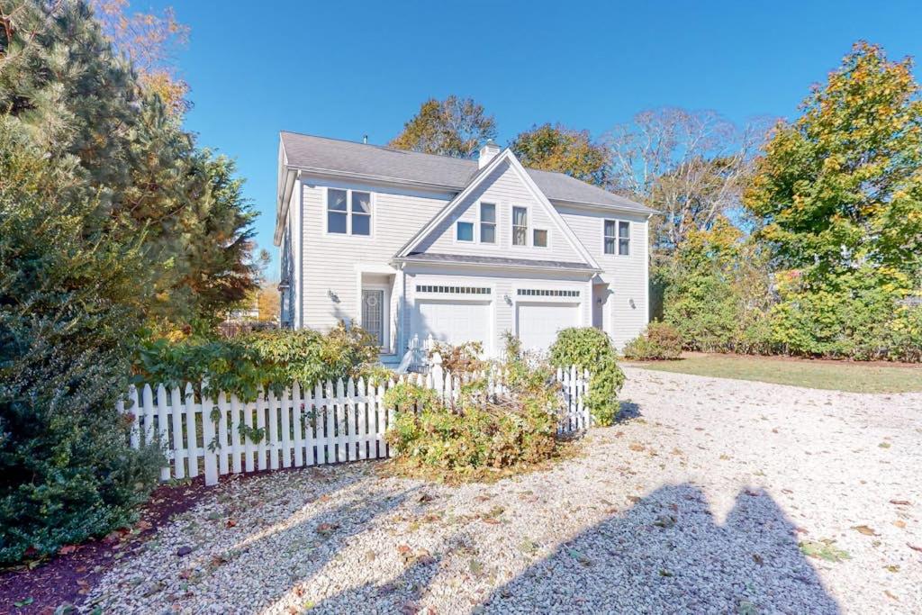 a white house with a white picket fence at Modern Beach & Town Getaway in Falmouth