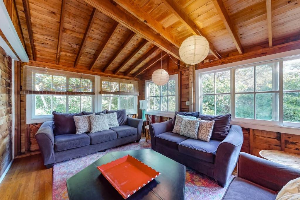 a living room with two couches and a table at Beachroad Hideout in Lobsterville