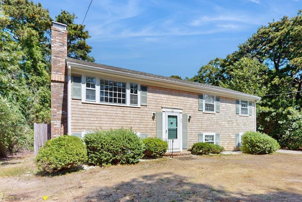 a brick house with bushes in front of it at Seabreeze in Dennis Port
