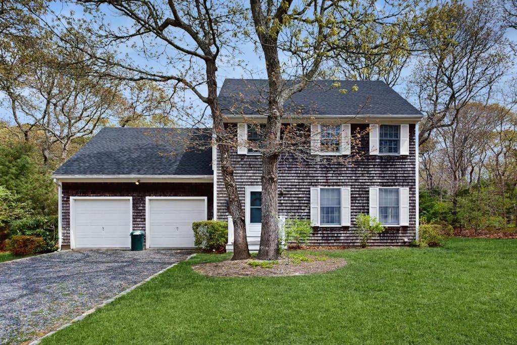 a brick house with a tree in the yard at Fallen Oak Retreat in Oak Bluffs