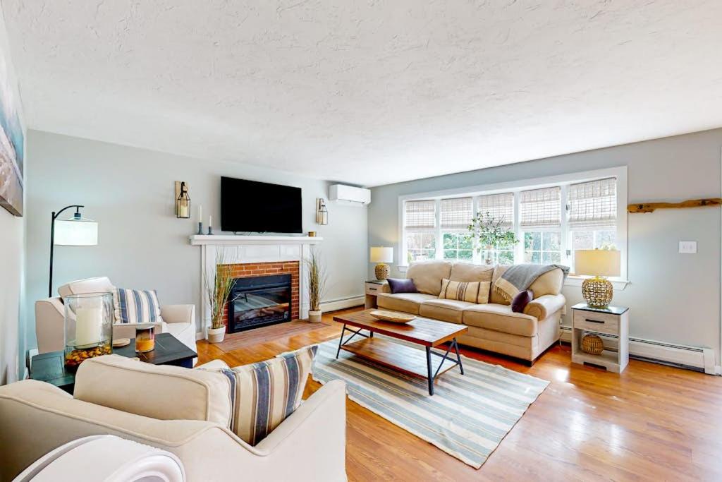 a living room with a couch and a fireplace at Megansett Glen in North Falmouth