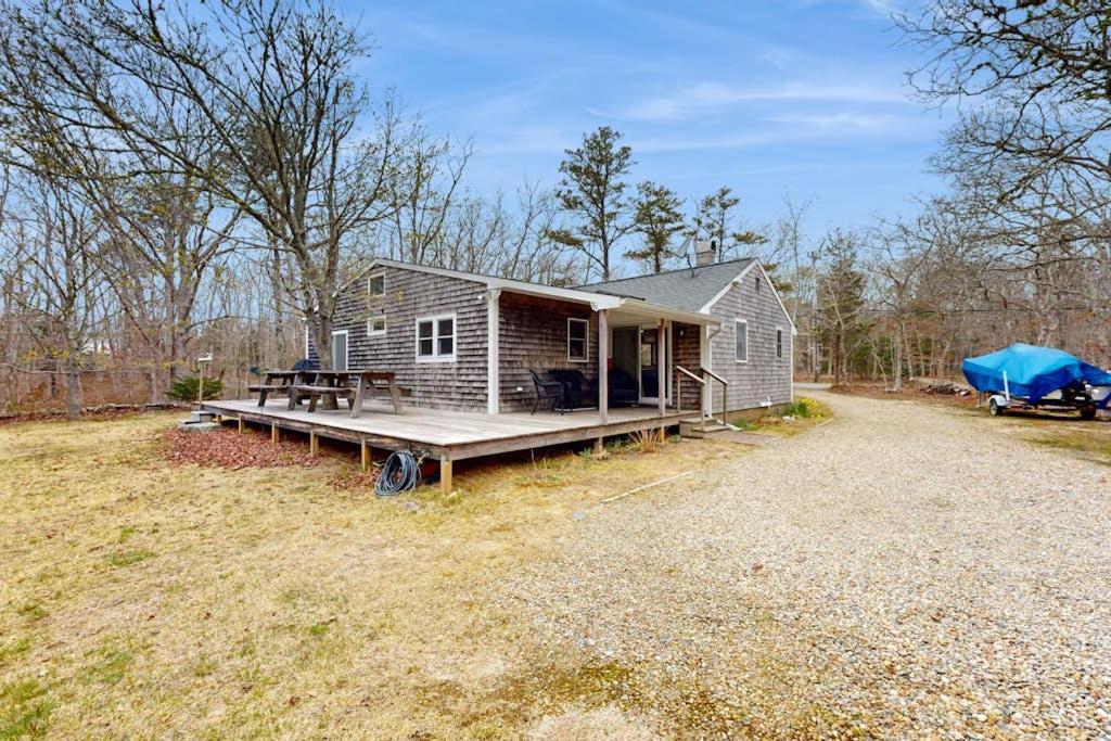 a tiny house with a porch and a truck parked in a field at C-Haven in West Tisbury