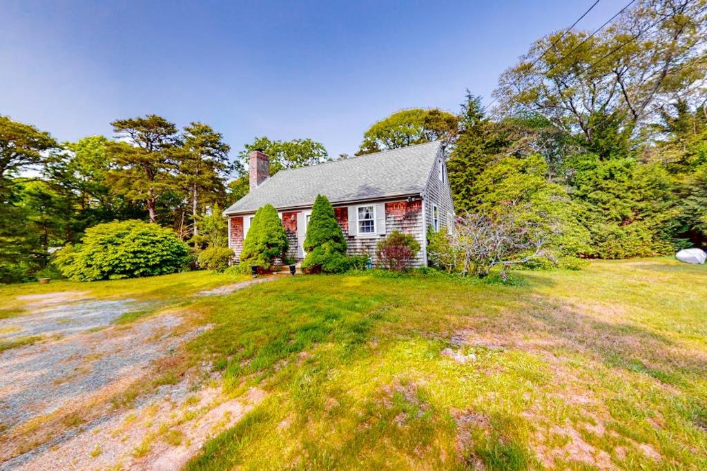 ein rot-weißes Haus auf einem grasbewachsenen Feld in der Unterkunft Haven Cottage in Brewster