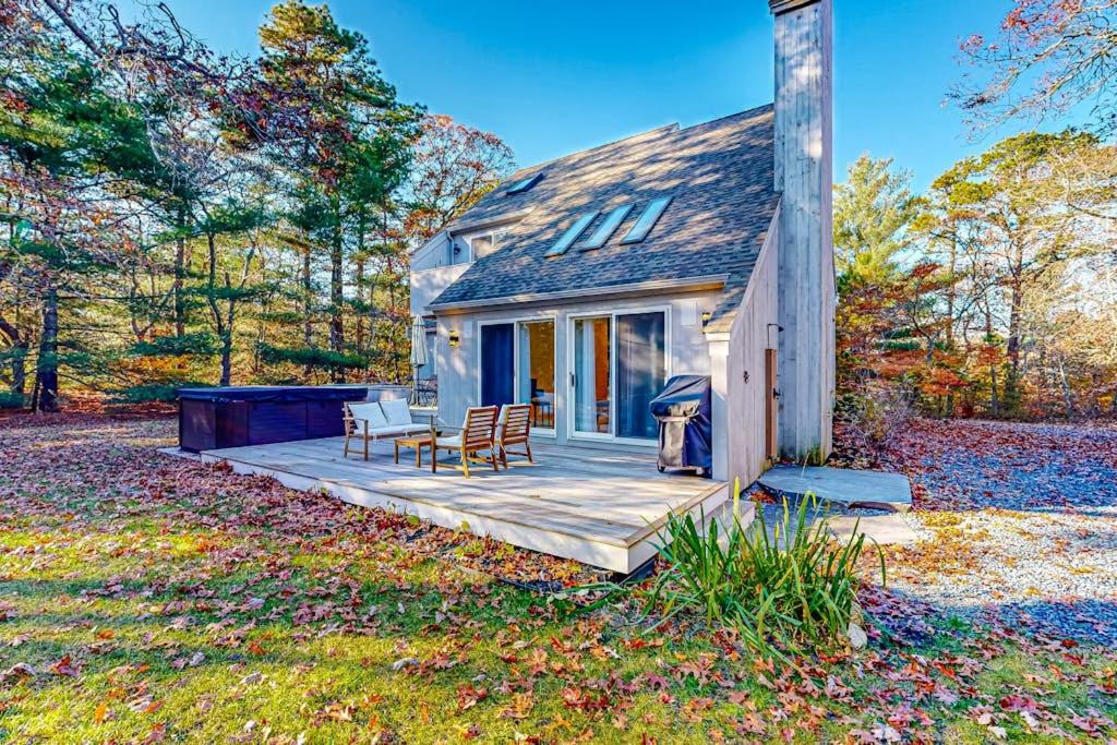a small house with a wooden deck in the woods at Tiffany's Treasure in Oak Bluffs