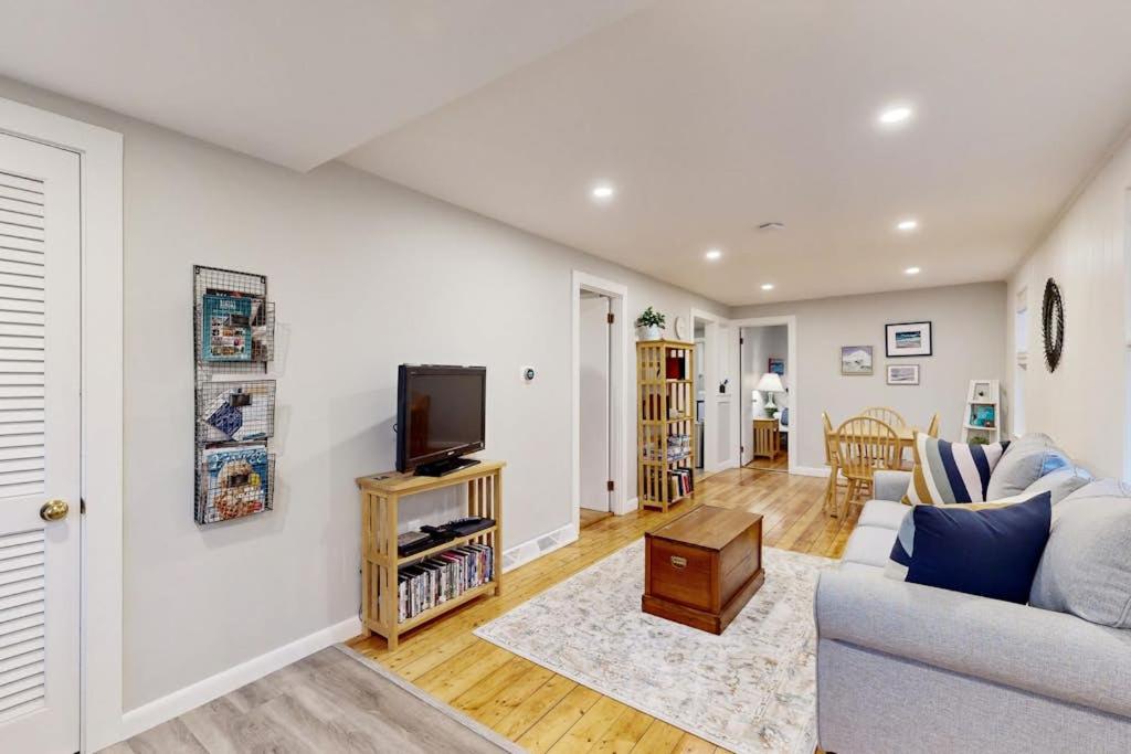a living room with a couch and a tv at Seabreeze Escape in Barnstable
