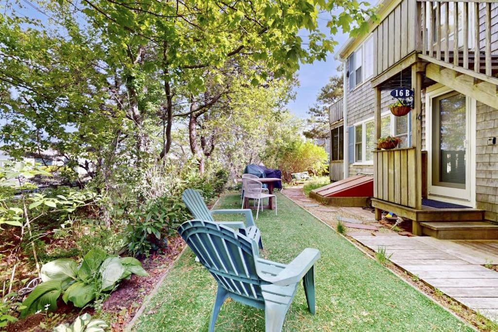 a yard with two blue chairs in front of a house at Endless Summer in Provincetown