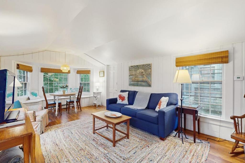 a living room with a blue couch and a table at Little Cozy Corner in Edgartown
