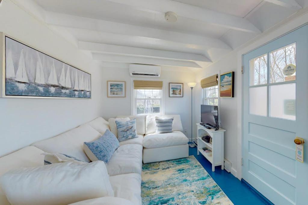 a living room with a white couch and a tv at Cottage by the Bay in Pocasset