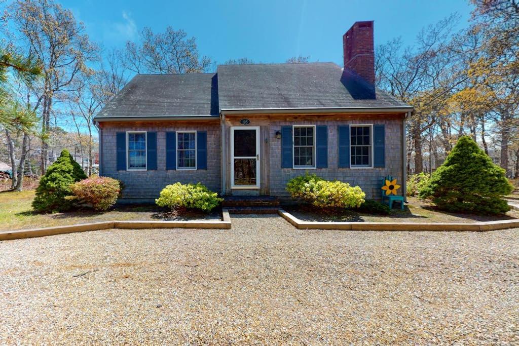 a blue house with a driveway in front of it at The Tranquil Heron Cottage in Eastham