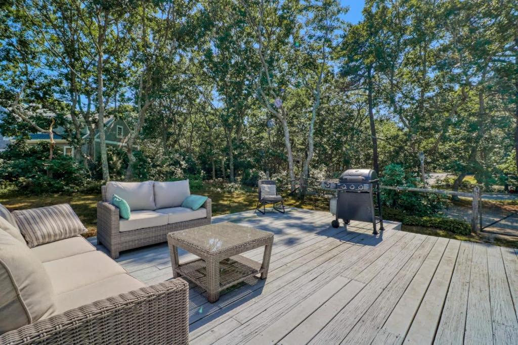 eine Terrasse mit Sofa und Grill auf einem Holzdeck in der Unterkunft Martha's Hideaway in Edgartown