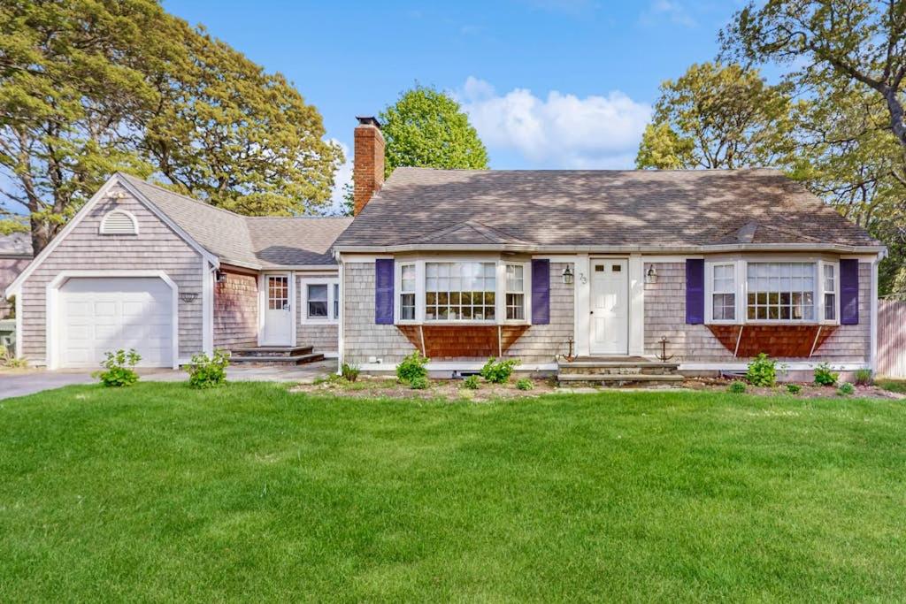 a house with a green lawn in front of it at Strawberry Hill Haven in Hyannis
