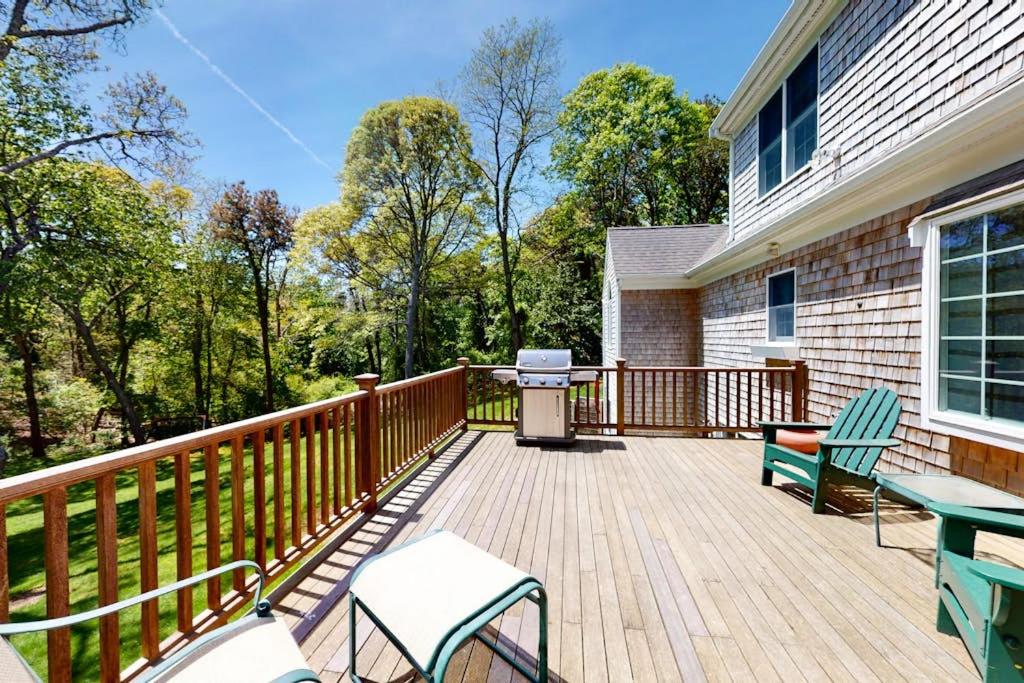 a deck with two chairs and a grill on a house at Spinnaker Trail in Orleans