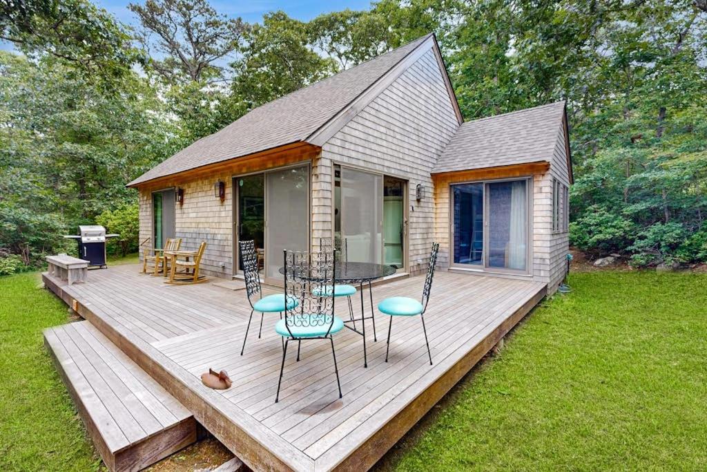 a wooden deck with a table and chairs on it at Chilmark Guest House in Chilmark