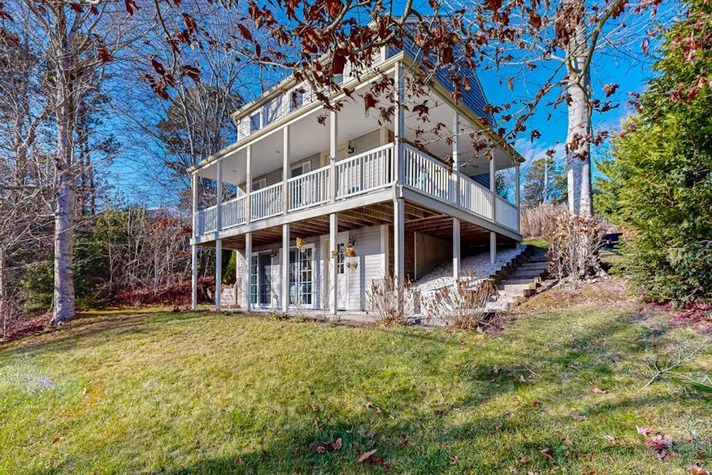 a large white house on a hill with a yard at Pond View Getaway in Sandwich
