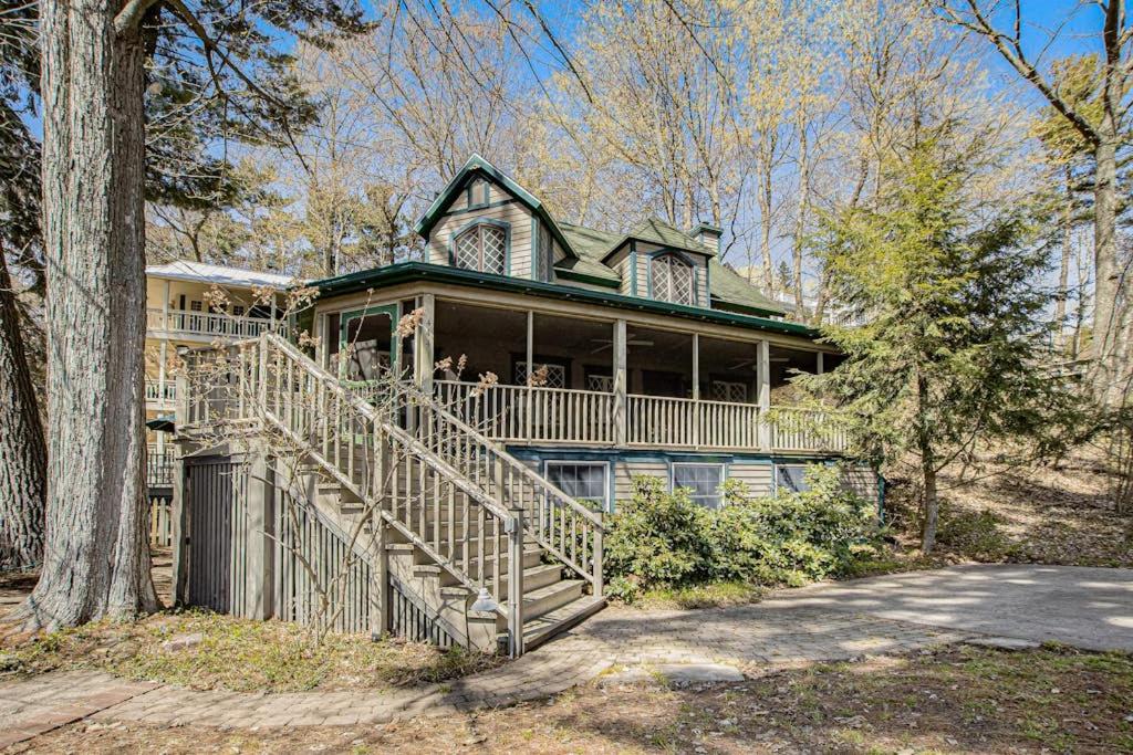 a large house with a staircase leading to a porch at Anna's Cottage in Saugatuck