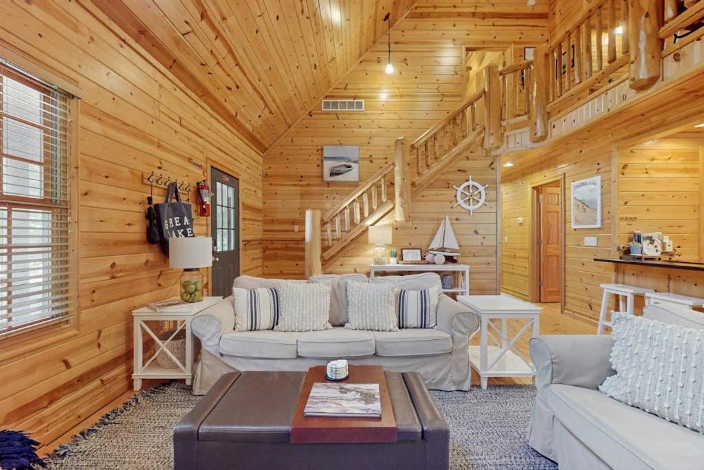 a living room with wooden walls and wooden ceilings at Kingfisher Cove Cabin 19 in Saugatuck
