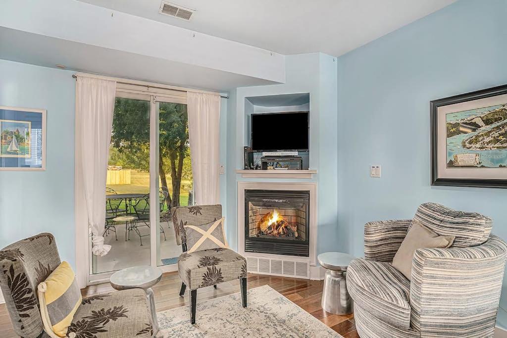 a living room with a fireplace and chairs and a television at Bluebird Condo in Douglas