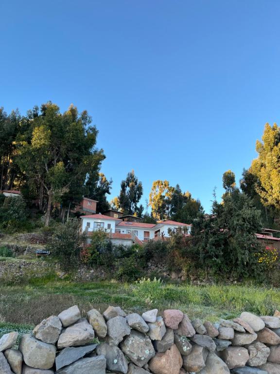 a pile of rocks in front of a house at Qocha Simi Homestay in Ocosuyo