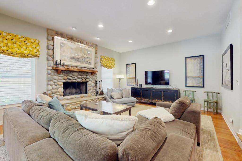 a living room with a large couch and a fireplace at Grand Getaway in Grand Beach