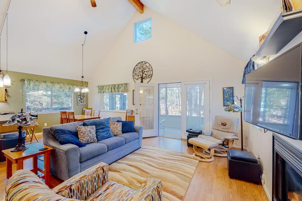 a living room with a blue couch and a fireplace at Uncle Warren's Retreat in Glen Arbor