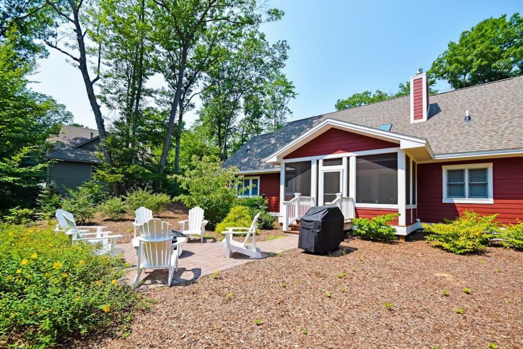 a yard with white chairs and a house at Cardinal Corner in Glen Arbor