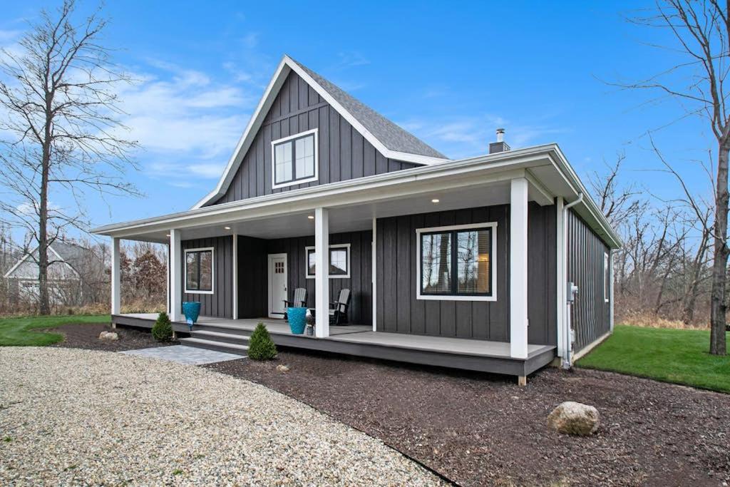 a gray house with a gambrel roof at Hidden Serenity in Sawyer