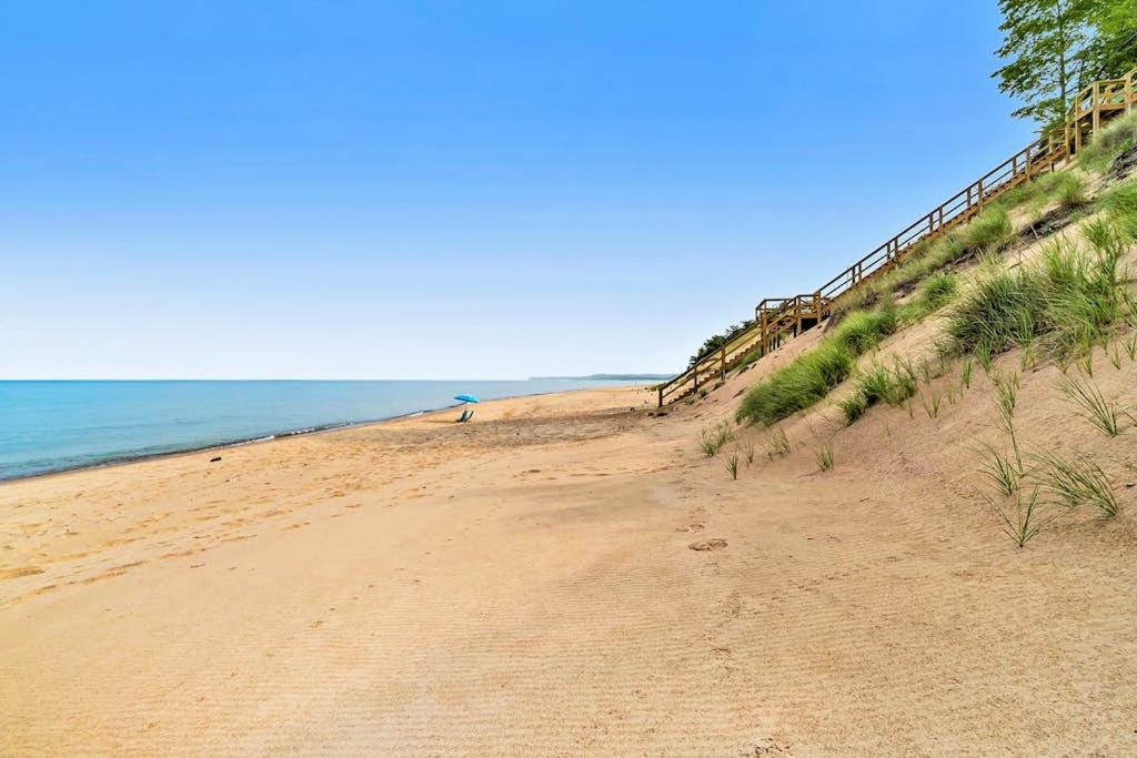 a sandy beach with the ocean in the background at Dune House in Manistee
