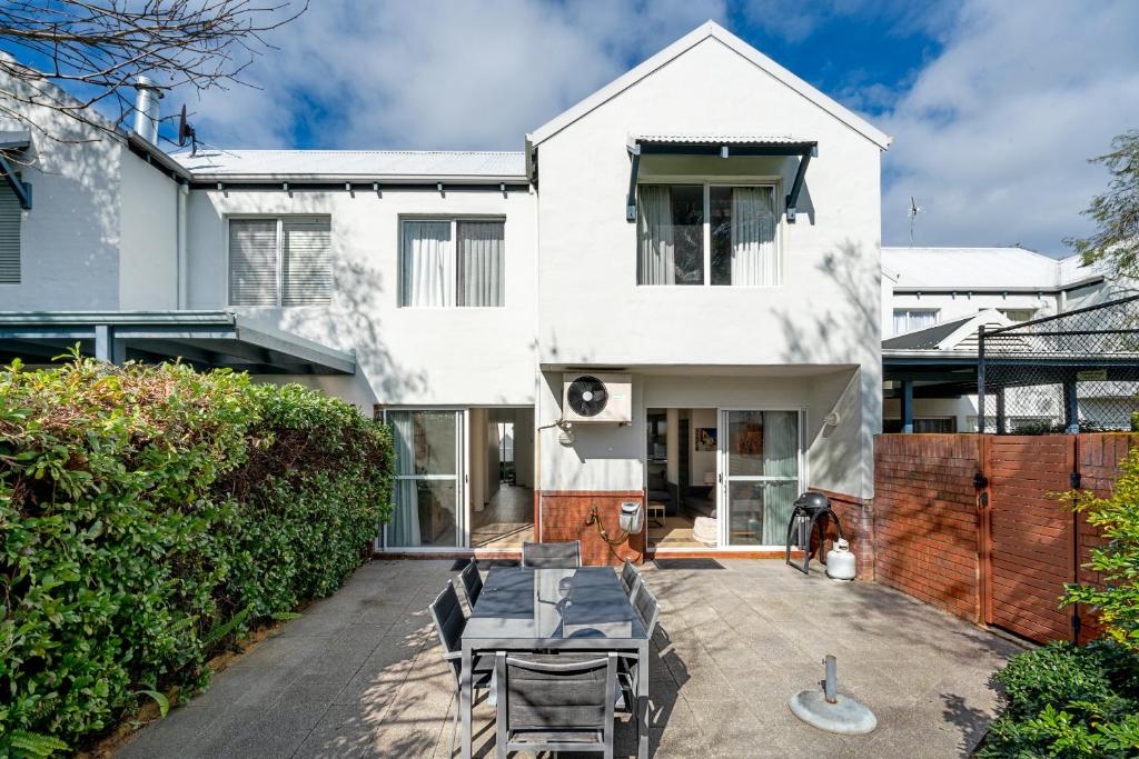 a white house with a patio in front of it at Abby’s Beach Villa in Broadwater