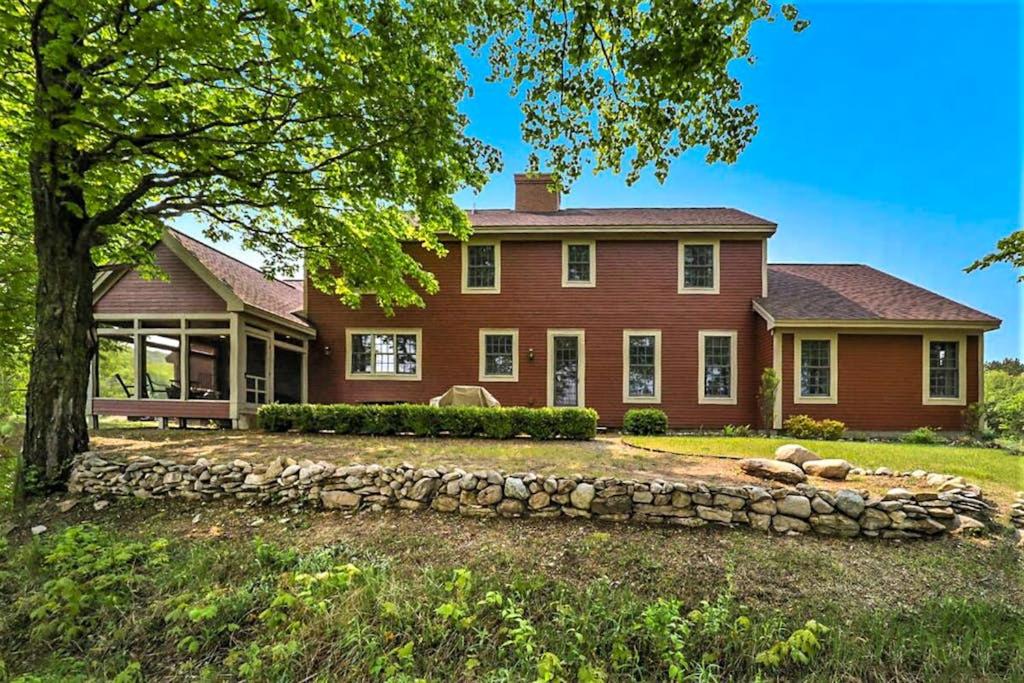 a large red house with a stone wall at Sorellina House in Maple City
