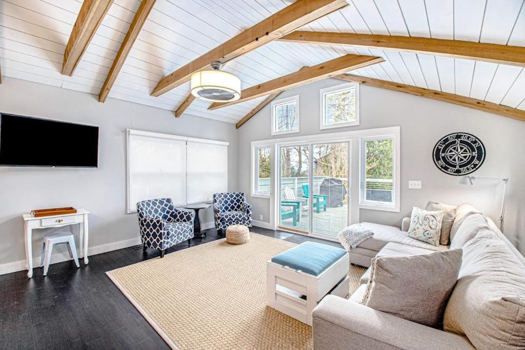 a living room with a couch and a tv at The Gatehouse on Orchard Beach in Lakeside