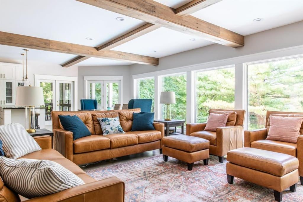 a living room with leather furniture and windows at Mac's Bluff in Grand Beach