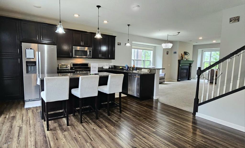 a kitchen with black cabinets and white counter tops at River Valley Stay in Eagan