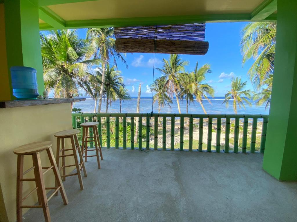 a view of the ocean from the balcony of a resort at Kapunoan Beach House in Burgos