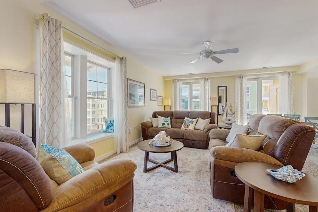 a living room with couches and tables and windows at The Sanctuary - Blue Lagoon A323 in Virginia Beach