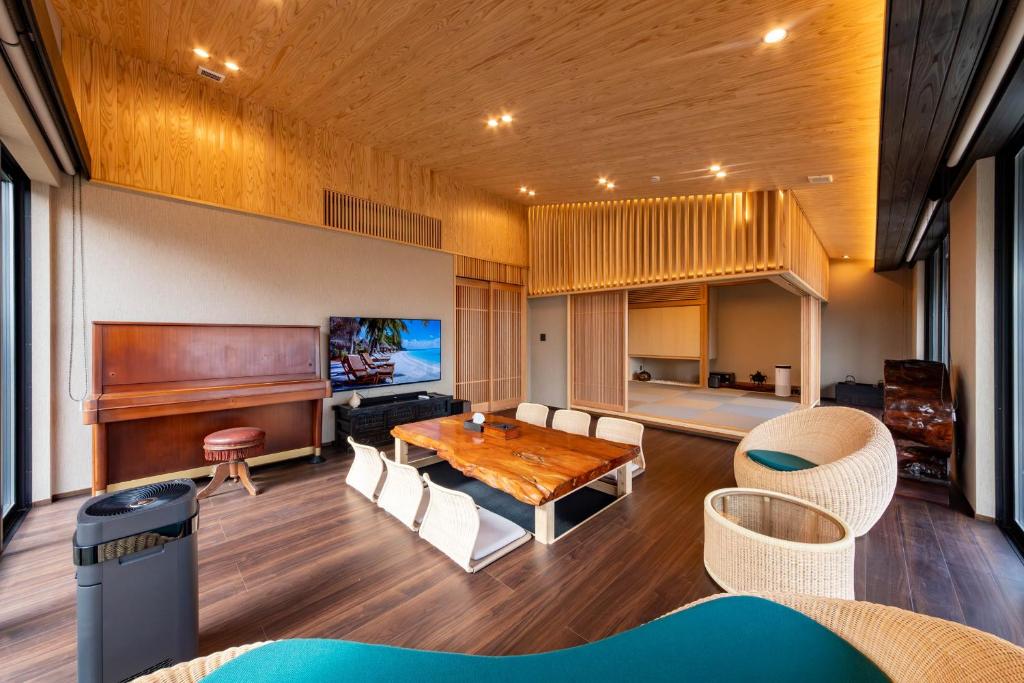 a living room with a table and a piano at 貞芙庵 in Ichinomiya