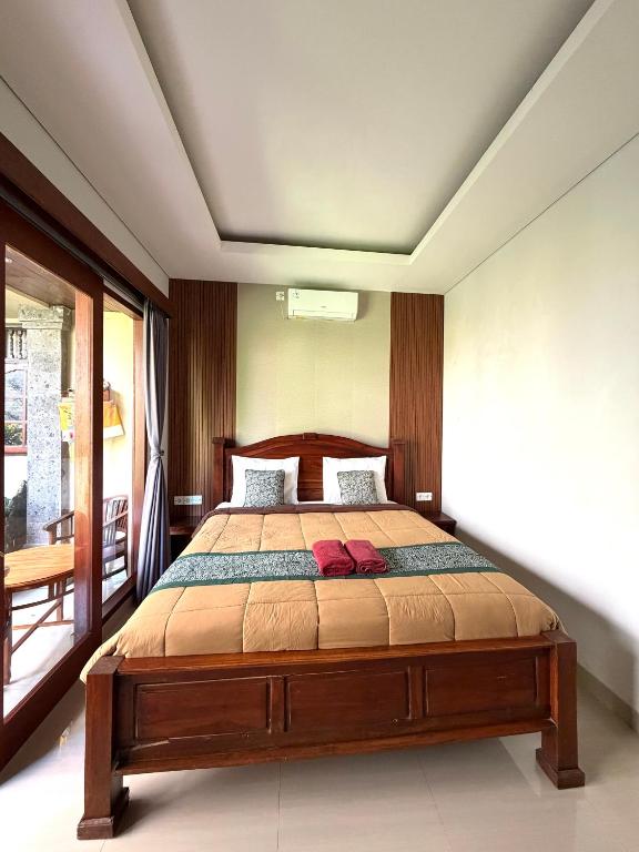 a bedroom with a wooden bed in a room at Kope House Ubud in Ubud