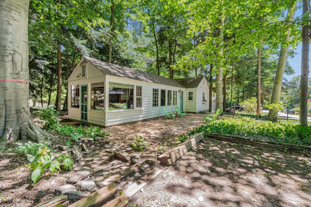 a small white house in the middle of the woods at Cottage Living in Beulah
