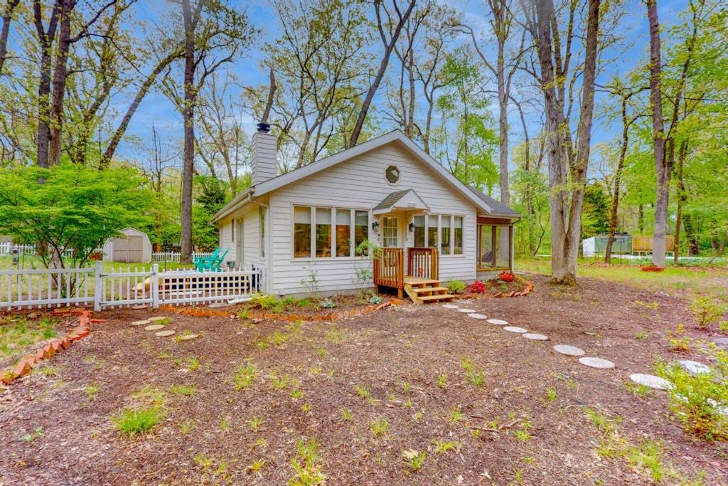 a small white house in the middle of a yard at Livywood Cottage in New Buffalo