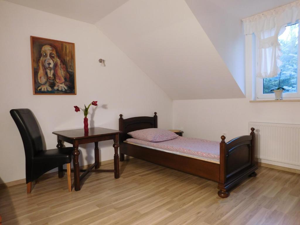 a bedroom with a bed and a table and a window at Agroturystyka pod Czarną Sosną in Biały Ług