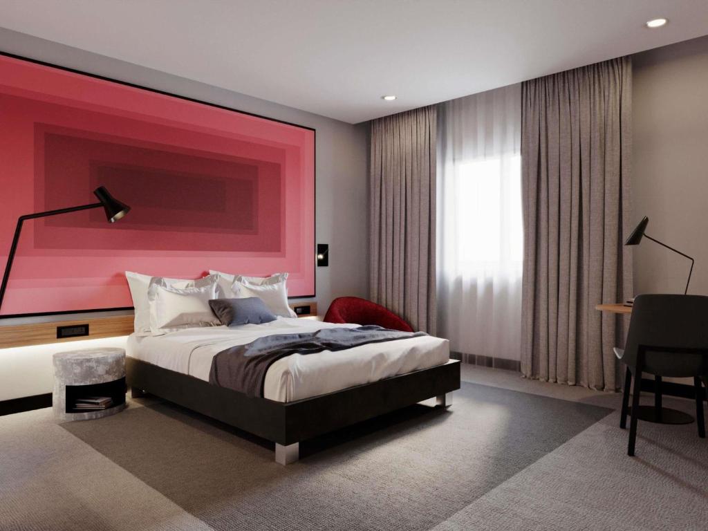 a bedroom with a large bed and a pink wall at IBIS LAGOS LEKKI in Lagos