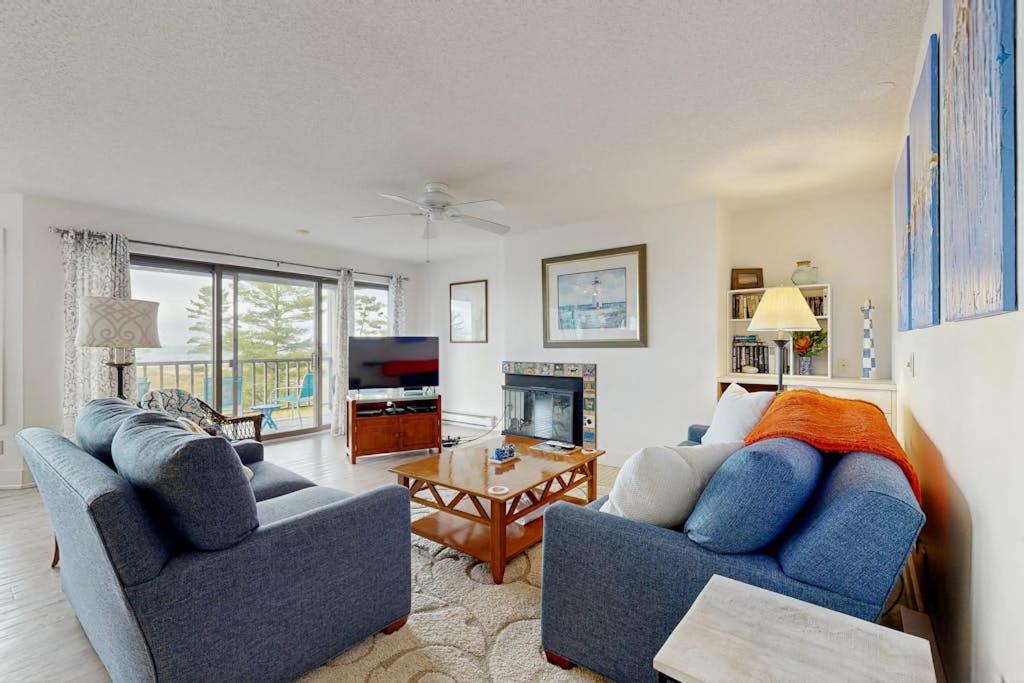 a living room with two blue couches and a television at South Beach 43 in Glen Arbor