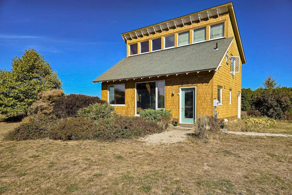 a yellow brick house with a roof on a hill at Green Pastures in Maple City