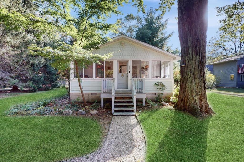 a small white house with a tree in the yard at Lilly Bell Villa in Three Oaks