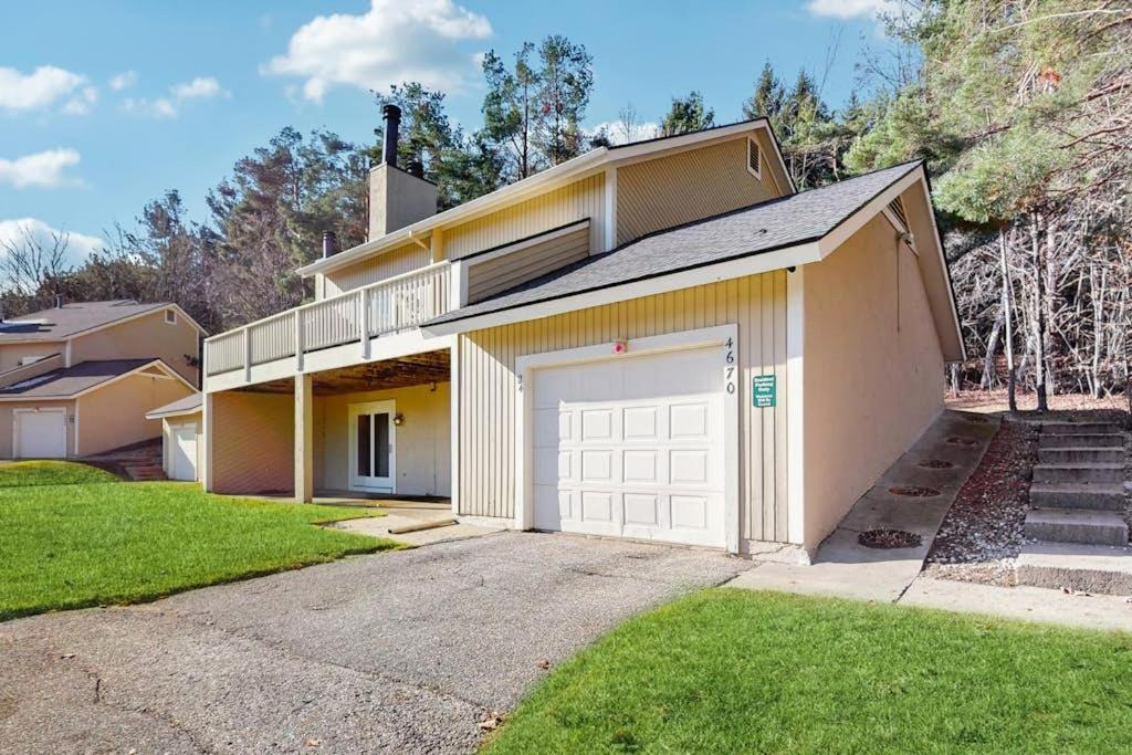 a large house with a garage and a driveway at Ski & Tee Boyne Highlands Townhouse in Harbor Springs