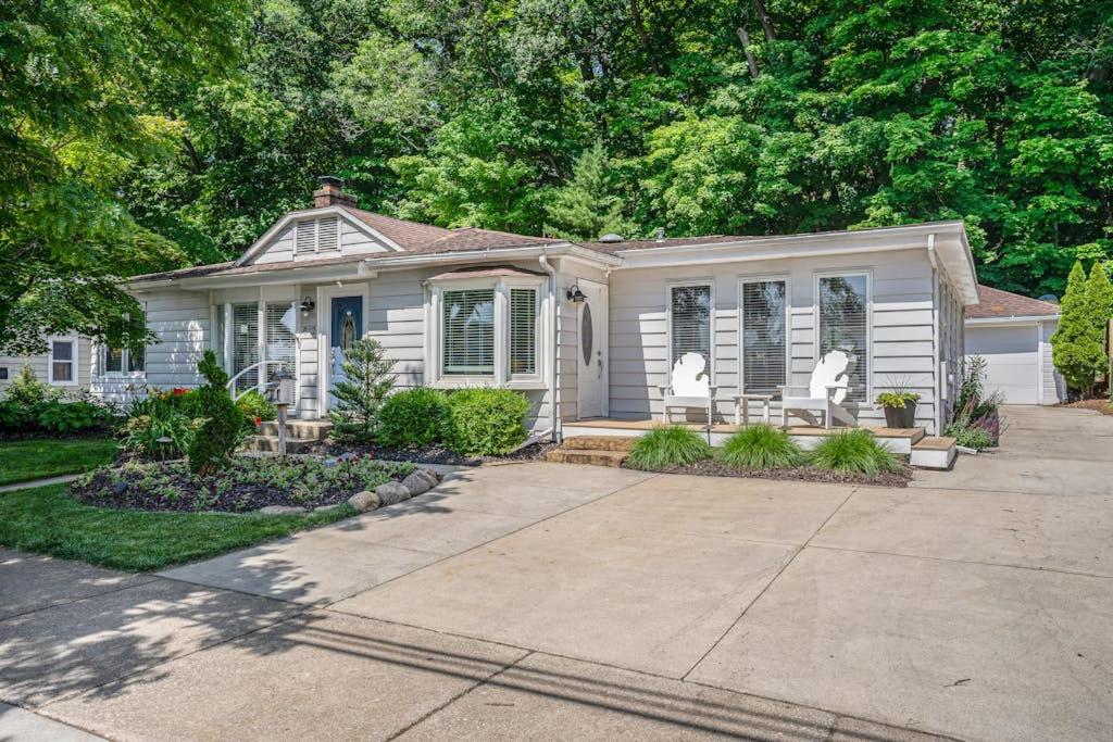 a white house with a porch and a driveway at Serenity Now in Saugatuck