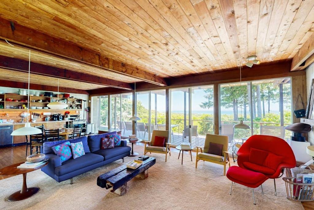 a living room with a blue couch and chairs at The Eliot Noyes in Chilmark