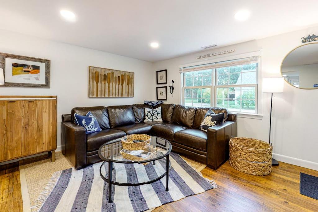 a living room with a leather couch and a table at Harbortown Hideaway in Falmouth
