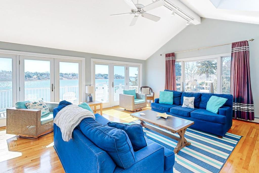 a living room with blue couches and a table at Island Bay Bungalow in Eastham