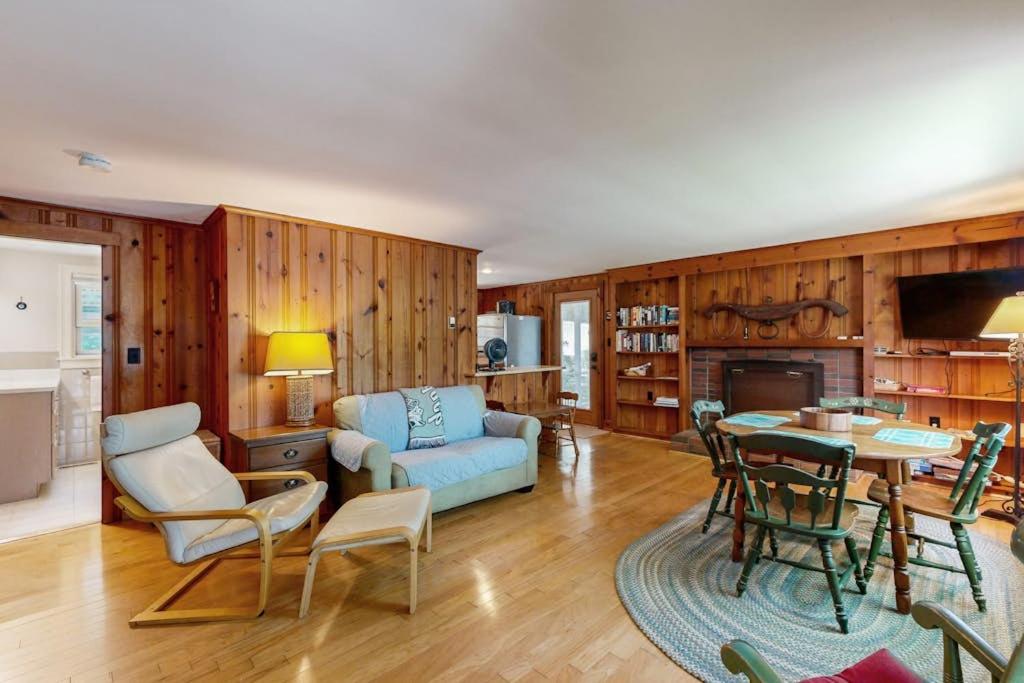 a living room with a couch and a table at Pickerel Cove Cottage in Mashpee