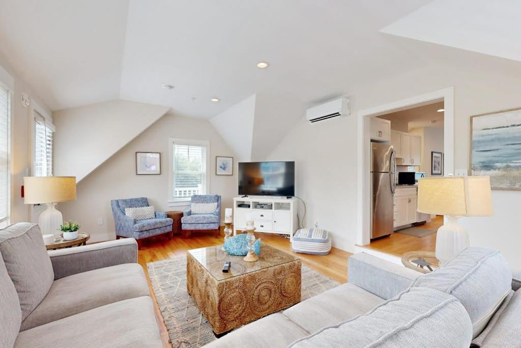 a living room with two couches and a table at Oyster Beach Bungalow in Chatham